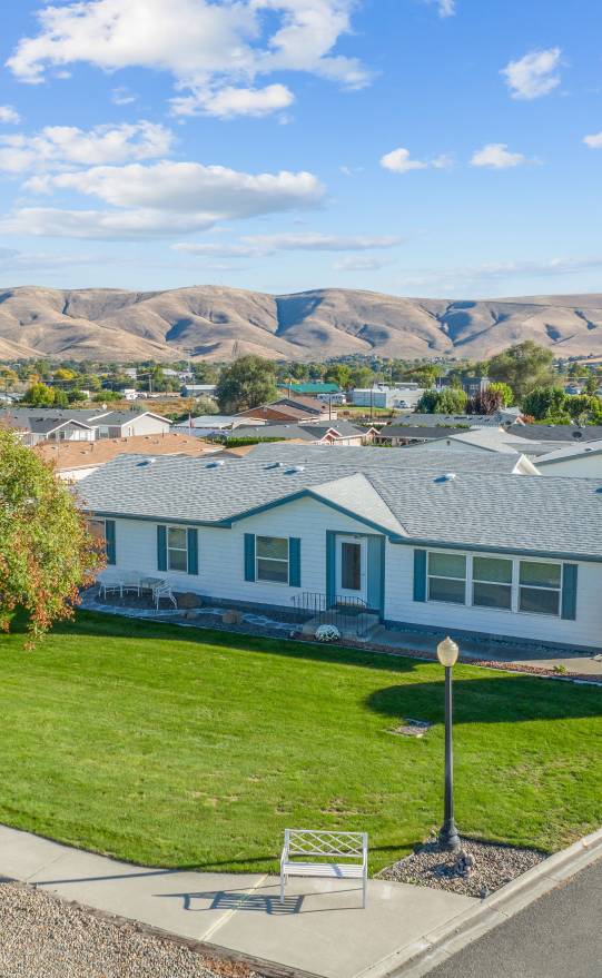 Photo looking down on house and community in the background