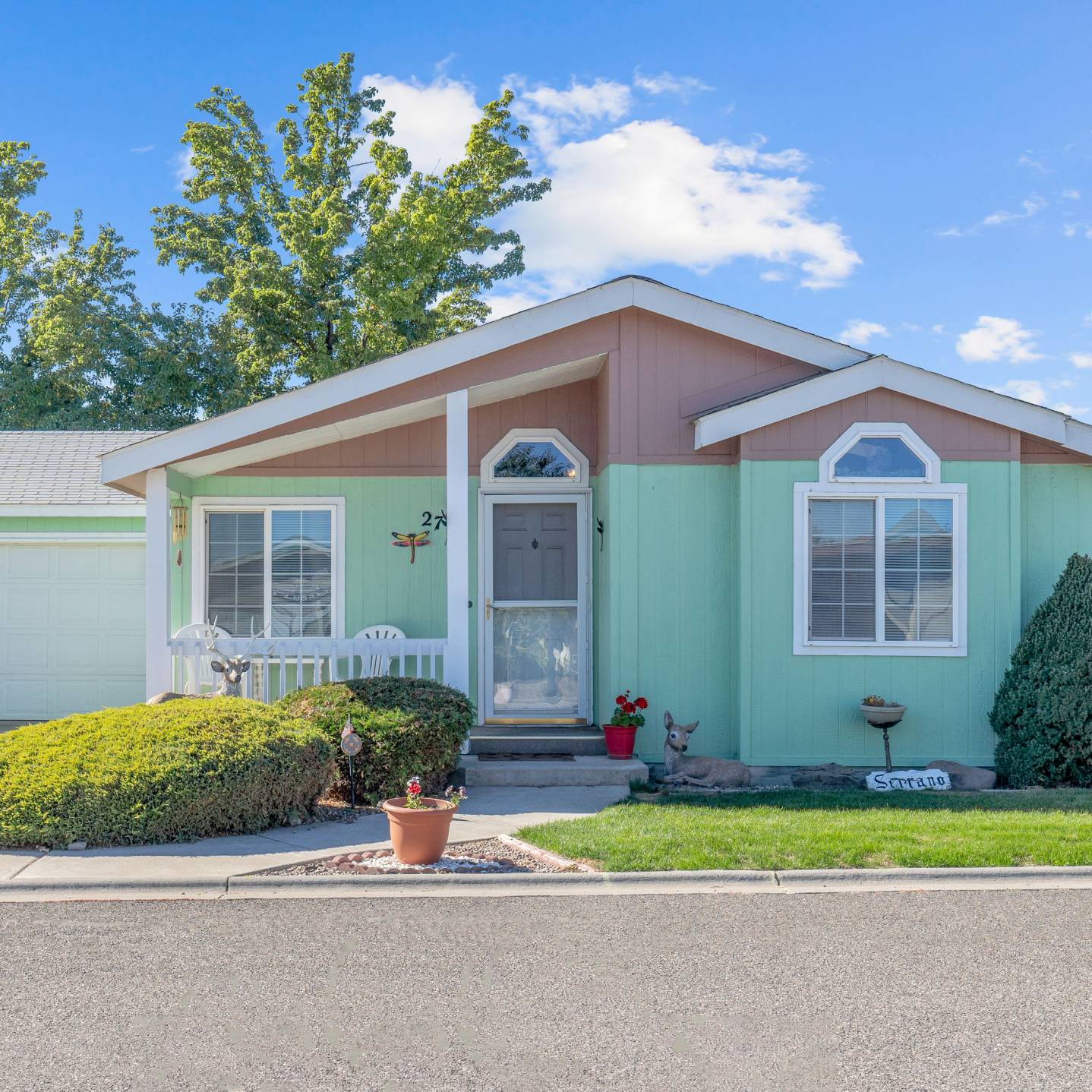 Photo of a gray and aqua marine colored house with white trim