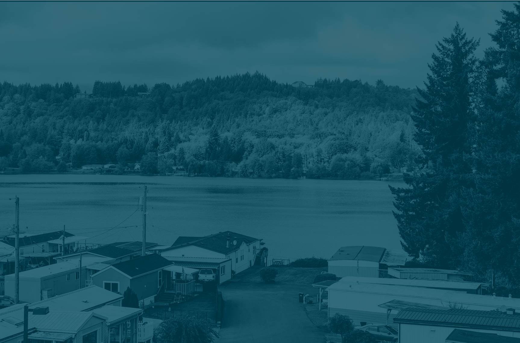 Photo of a manufactured home community on lake with mountains in the background