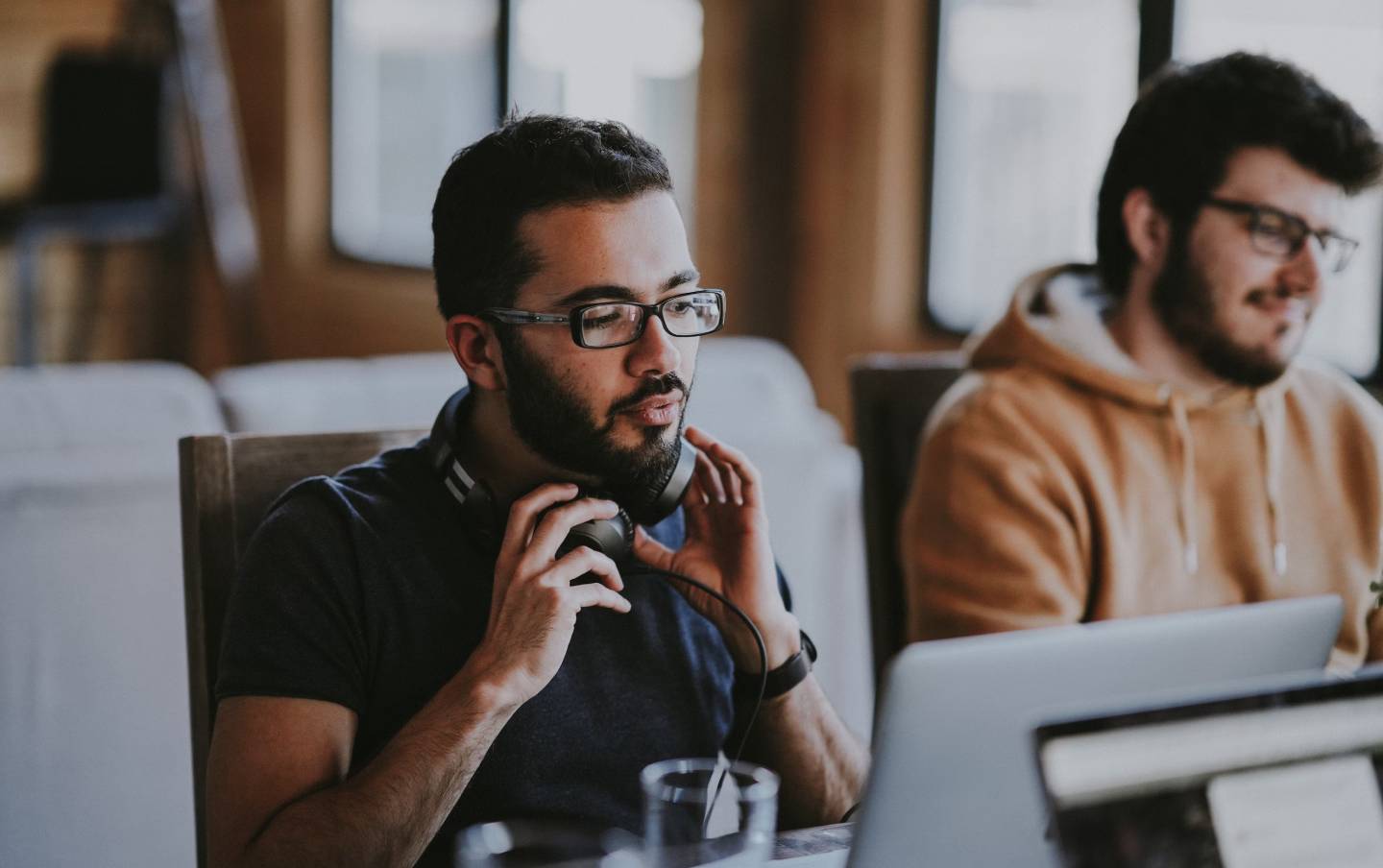 Photo of a person working at computer wearing headphones