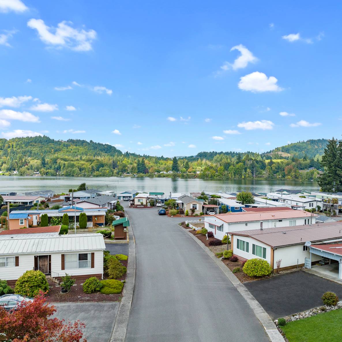 Photo of a street with houses on both sides leading to a lake